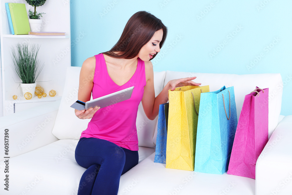 Beautiful young woman holding tablet with shopping bags Beautiful young woman holding tablet with shopping bags