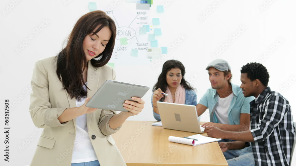Young creative team working together with woman using tablet Young creative team working together with woman using tablet