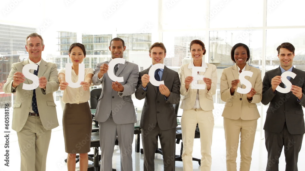 Happy business people holding letters spelling success Happy business people holding letters spelling success