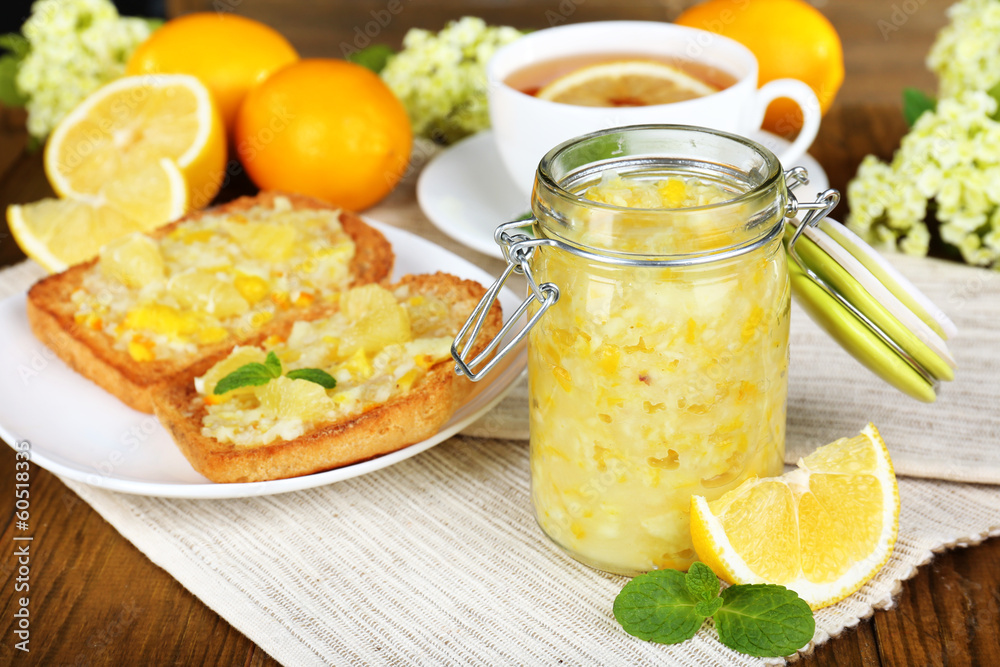 Tasty lemon jam with cup of tea on table close-up Tasty lemon jam with cup of tea on table close-up