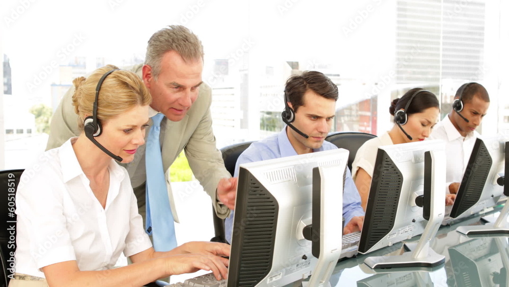 Manager checking in on call centre employees Manager checking in on call centre employees