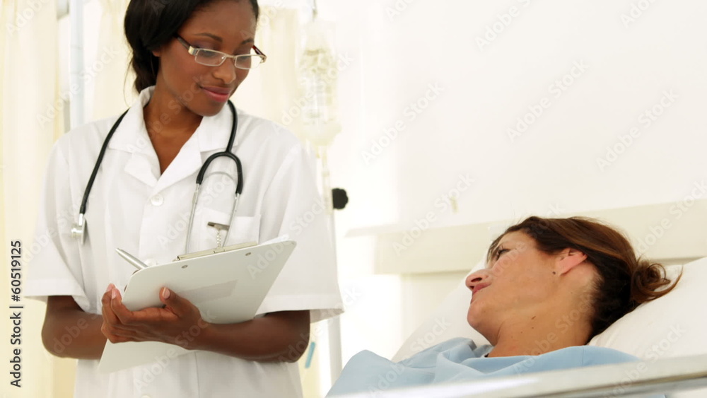 Smiling nurse checking on her patient Smiling nurse checking on her patient