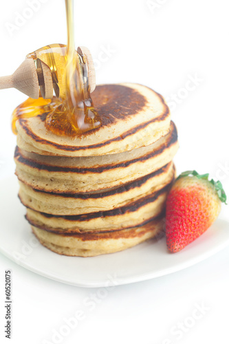 Pancakes, honey, strawberry and stick to honey isolated on white