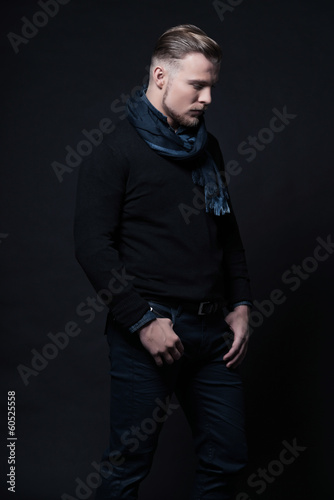 Man winter fashion. Wearing black sweater and scarf. Blonde hair © ysbrandcosijn
