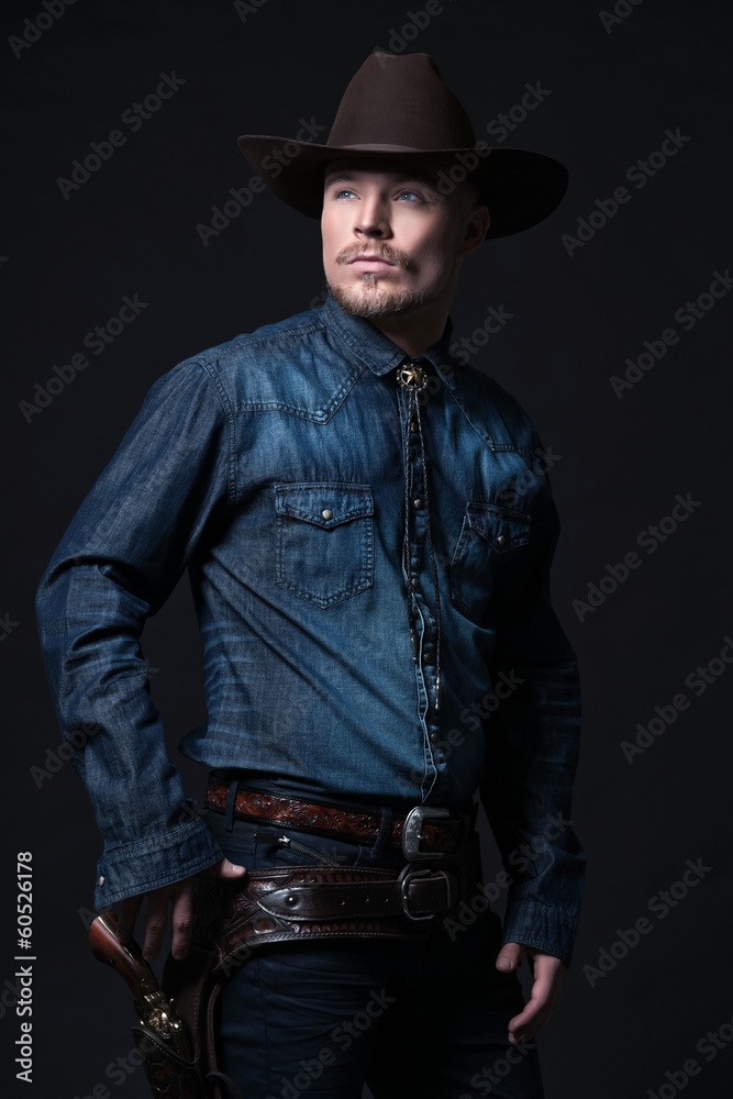 Modern fashion cowboy. Wearing brown hat and blue jeans shirt. P Modern fashion cowboy. Wearing brown hat and blue jeans shirt. P