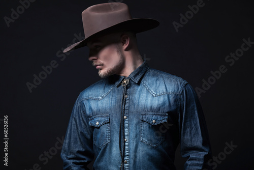 Obraz na płótnie Modern fashion cowboy. Wearing brown hat and blue jeans shirt. B w salonie