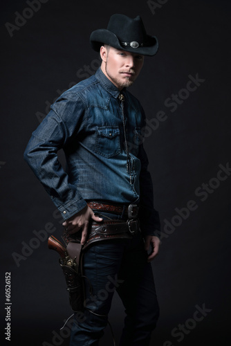Modern fashion cowboy. Wearing black hat and blue jeans shirt. P © ysbrandcosijn