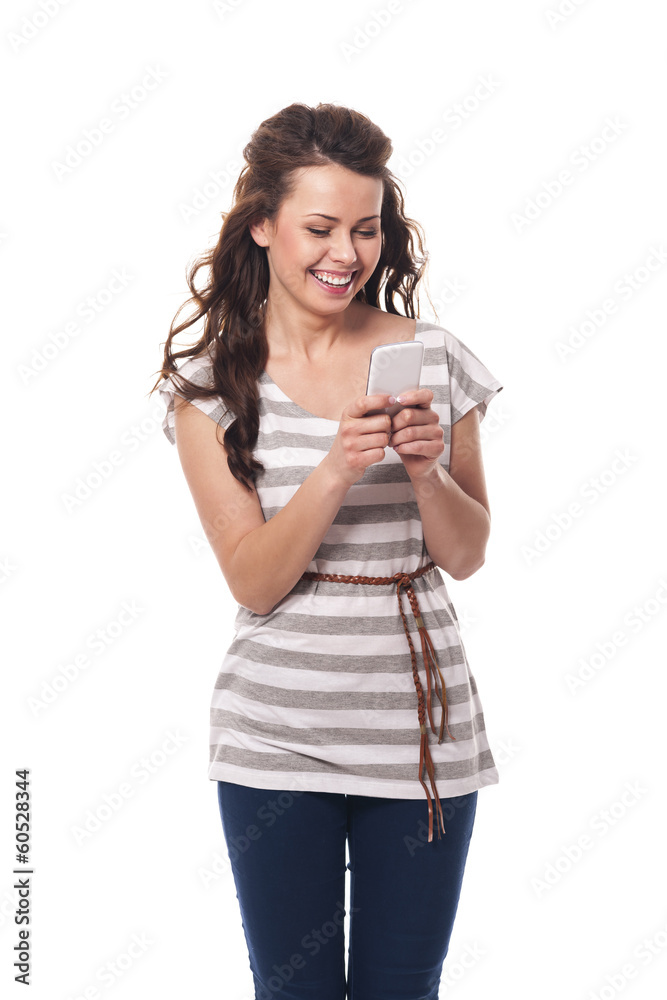 Smiling woman holding mobile phone and text messaging Smiling woman holding mobile phone and text messaging