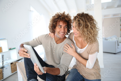 Happy couple at home websurfing on digital tablet