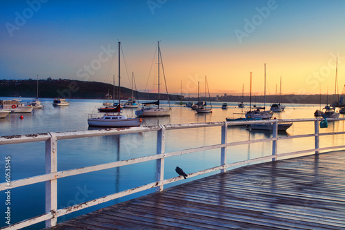 Boats moored bobbing in the waters at sunrise