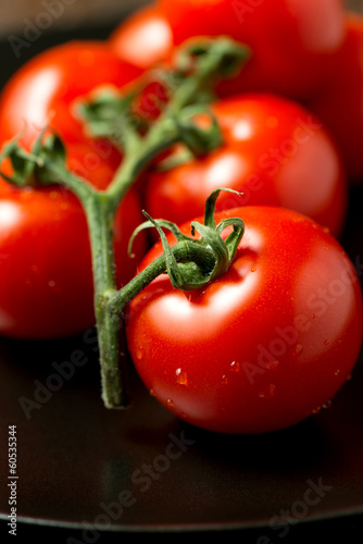 Tomatoes on plate angled view vertical