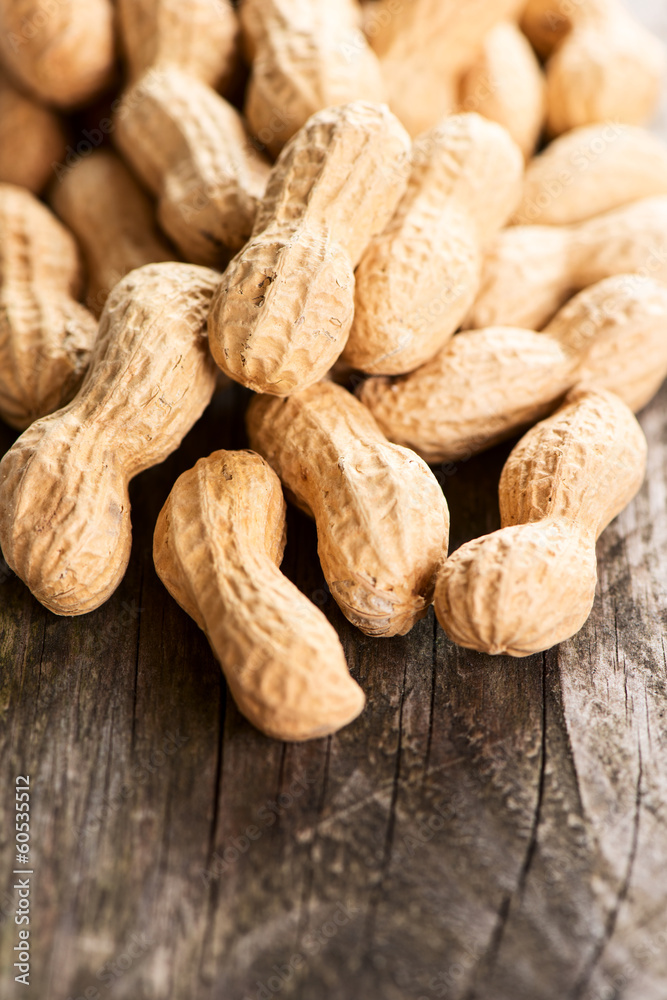 Peanuts in shell on wooden table vertical Peanuts in shell on wooden table vertical
