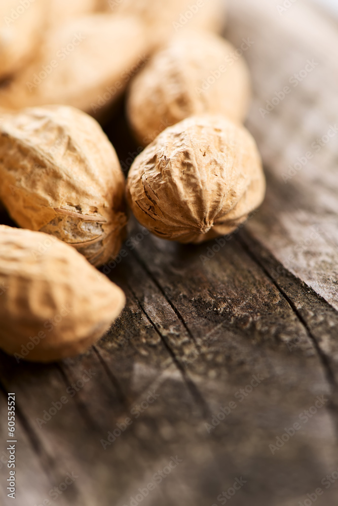 Peanuts in shell on wooden table vertical close up Peanuts in shell on wooden table vertical close up