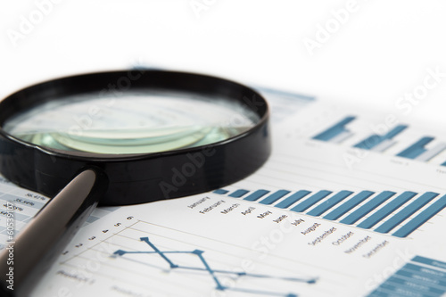 magnifying glass and pen over graph