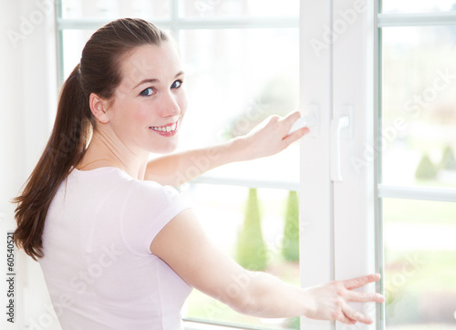 Attraktive Frau schließt Fenster © Kaesler Media
