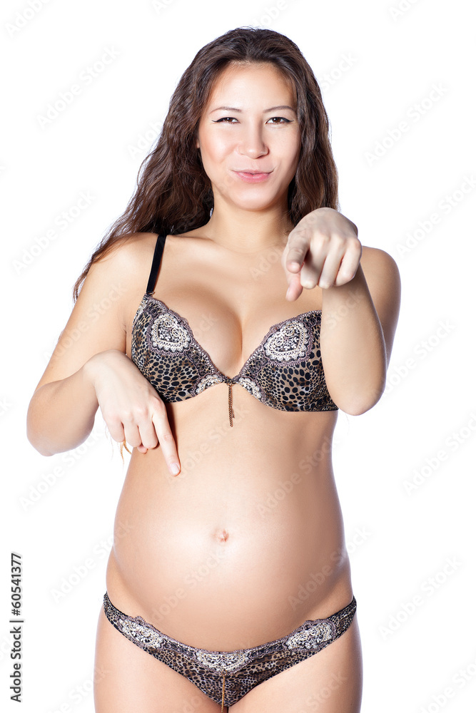 Beautiful pregnant woman points to the stomach.
