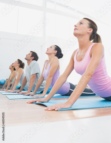 Class exercising in row at fitness studio