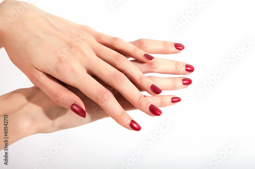Beautiful womens hands with red nails.