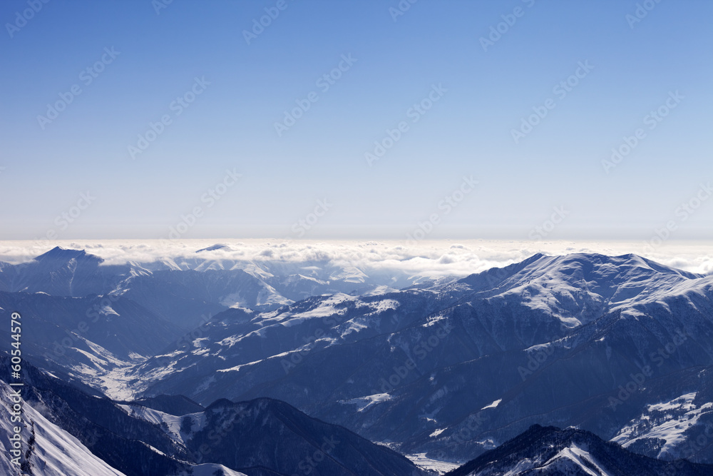 View from off-piste slope on snowy mountains in haze