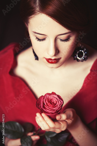 Beautiful redhead women with rose.