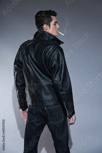 Retro rock and roll 50s fashion man with dark grease hair. Smoki
