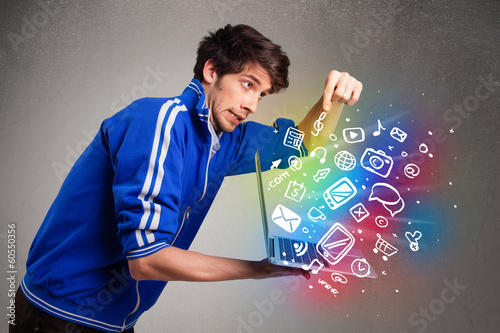 Casual man holding laptop with colorful hand drawn multimedia sy