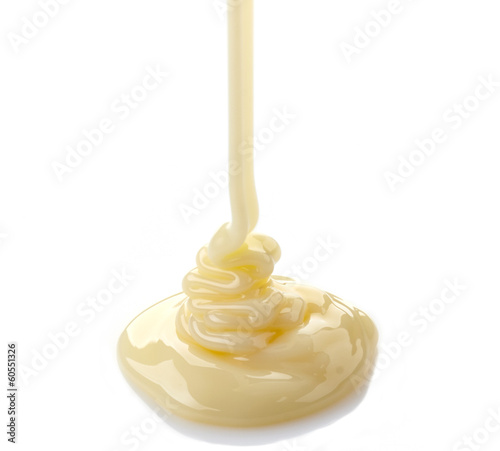 pouring condensed milk on a white background photo
