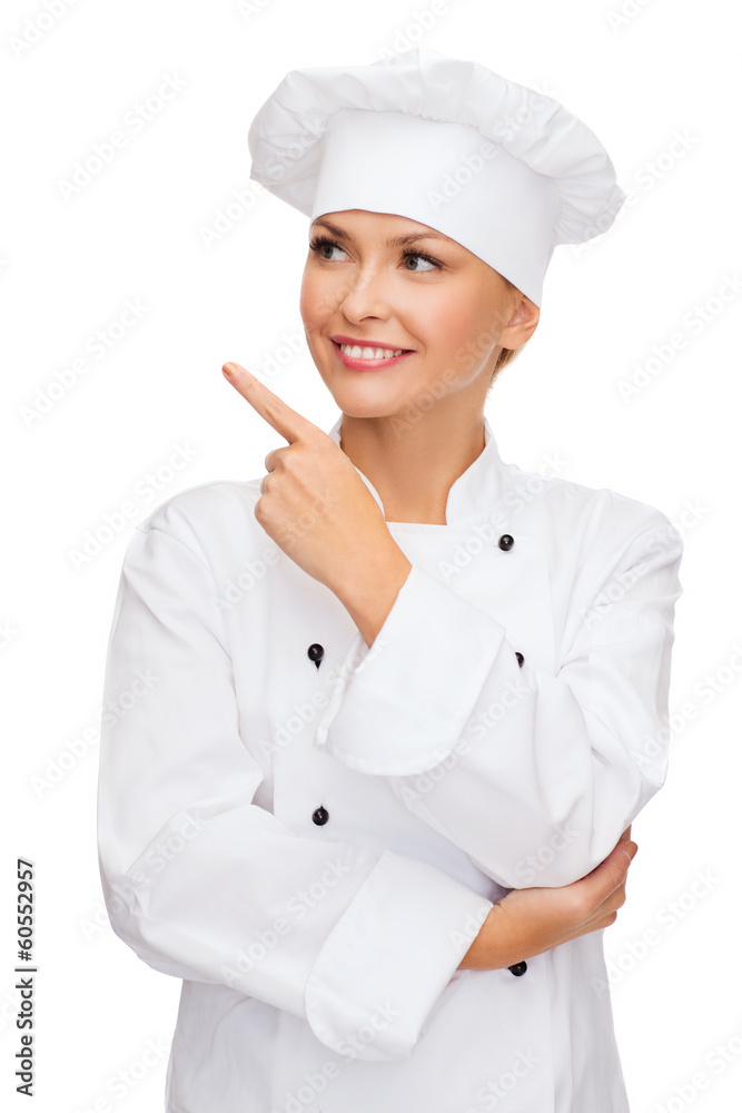 smiling female chef pointing finger to sonething smiling female chef pointing finger to sonething
