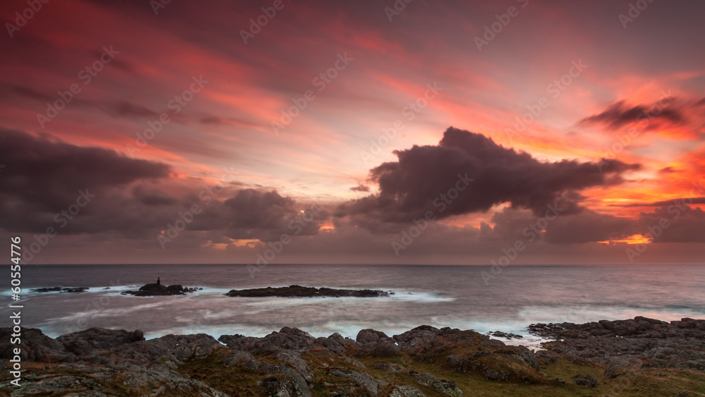 Obraz premium Dramatic fiery sunset rocky coastline Norway Rogaland North Sea stormy sky Egersund