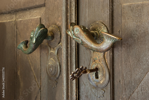 big old key in the door with fish handles