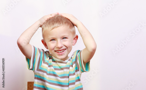 Portrait of surprised emotional blond boy child kid at the table