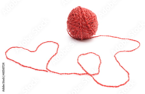 Heart shape and wool ball on white background