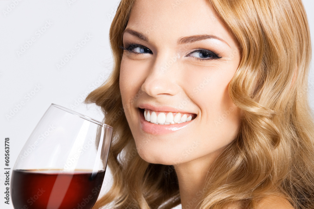 Young happy woman with glass of red wine, on gray Young happy woman with glass of red wine, on gray