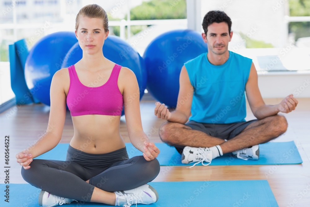 Young couple sitting in lotus posture at fitness studio Young couple sitting in lotus posture at fitness studio