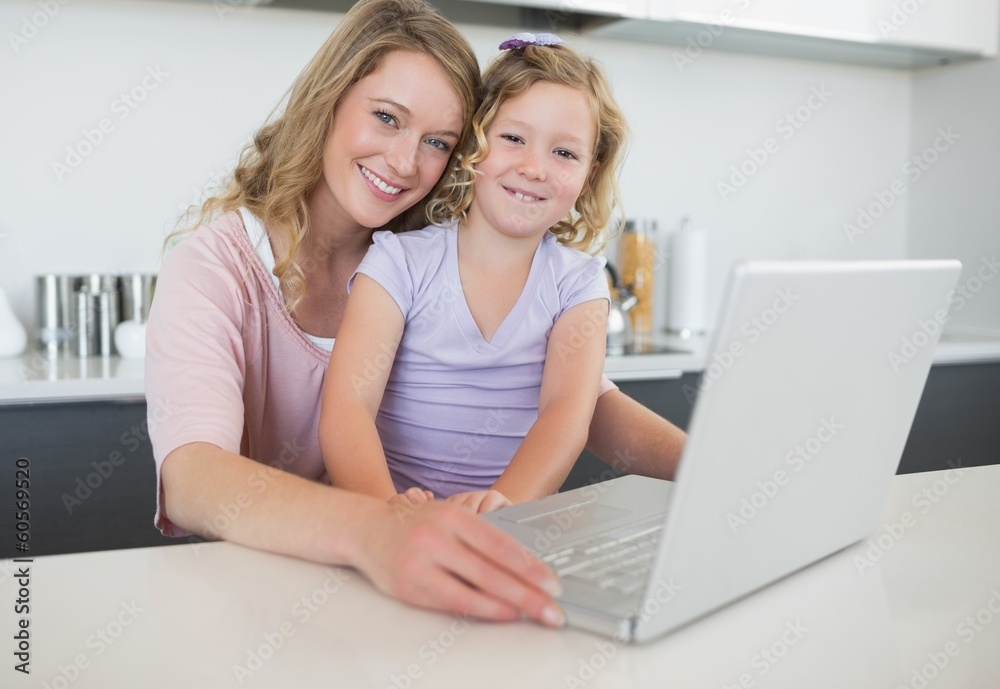 Mother and daughter with laptop at table Mother and daughter with laptop at table