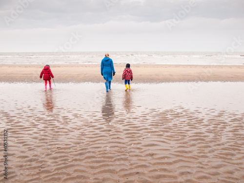 woman and two small children on winter beach