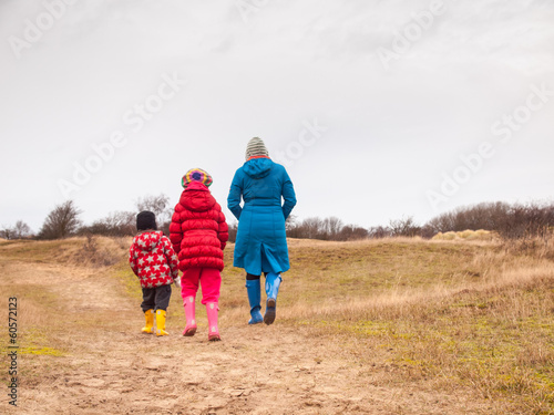 woman and two small children walking in a dunes in winter