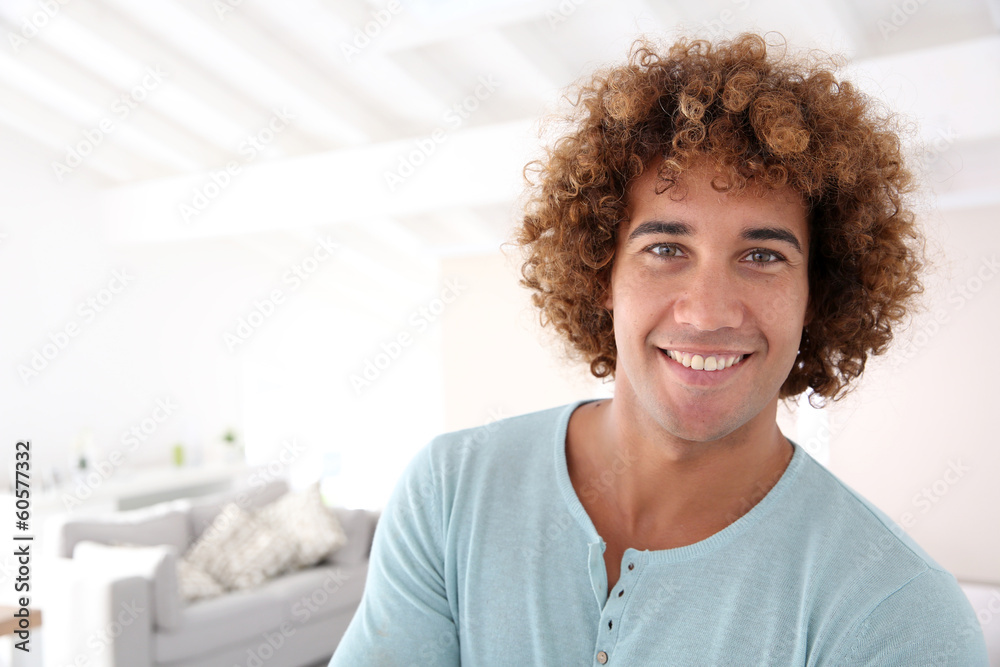 Handsome cheerful man standing in new home Handsome cheerful man standing in new home
