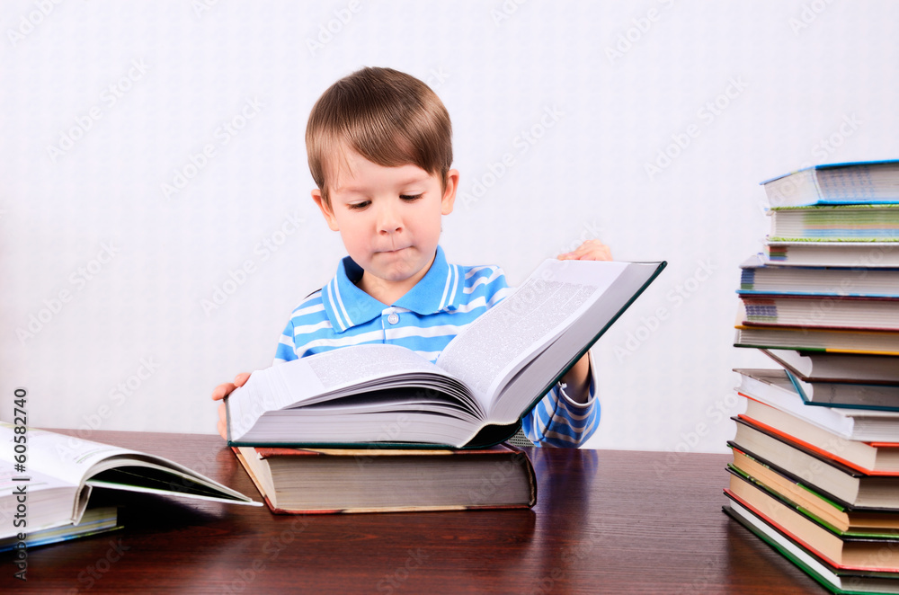 little boy opens a large book and looking into it little boy opens a large book and looking into it