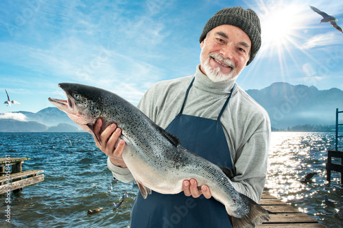 Fisher holding a big atlantic salmon fish