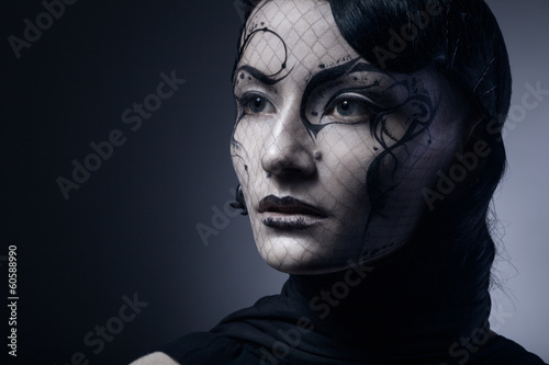 portrait of young gothic woman isolated on dark background with