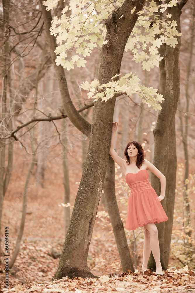 Fashion young woman in red dress relaxing in park Fashion young woman in red dress relaxing in park