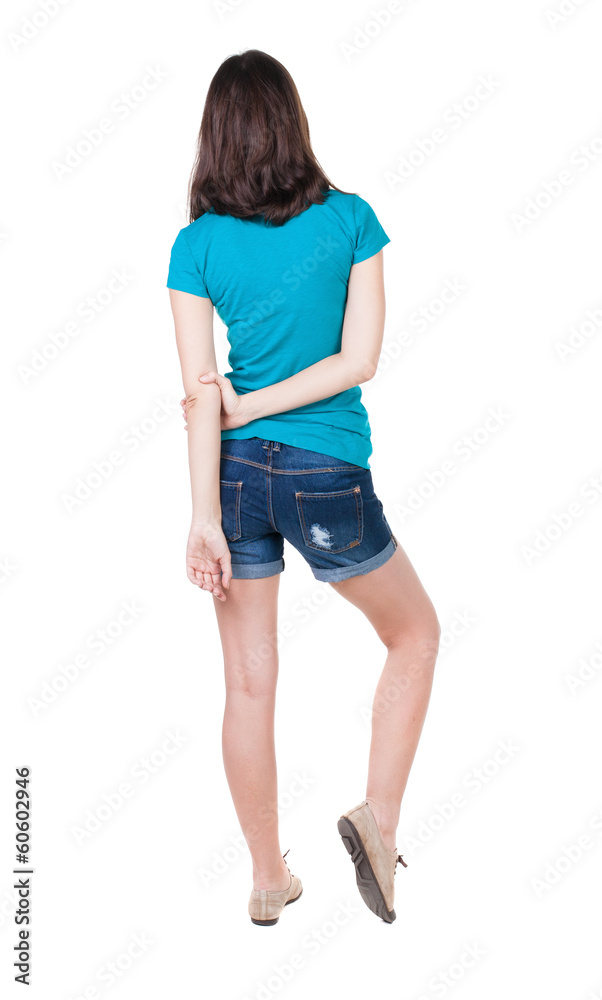 back view of standing young beautiful brunette woman in shorts. back view of standing young beautiful brunette woman in shorts.