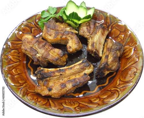 Traditional grilled pork ribs on the grill with fresh vegetables