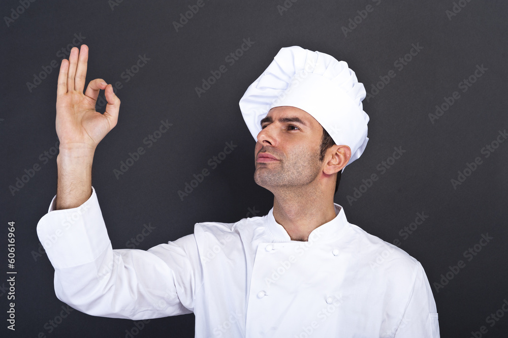 Male chef kissing fingers against grey background Male chef kissing fingers against grey background