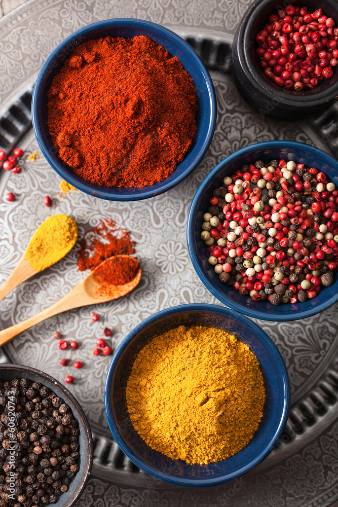 Fototapeta premium spices in bowls: curry pink and black pepper paprika powder