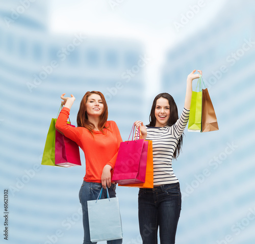 two smiling teenage girls with shopping bags photo