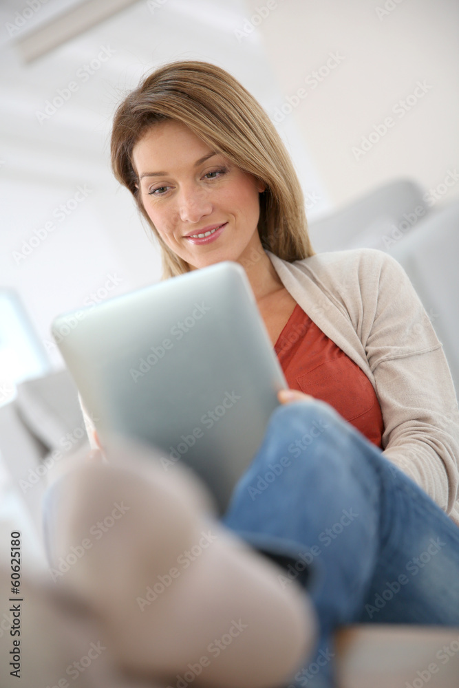 Woman at home connected on internet with tablet Woman at home connected on internet with tablet