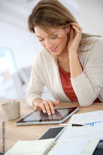 Woman working from home on digital tablet