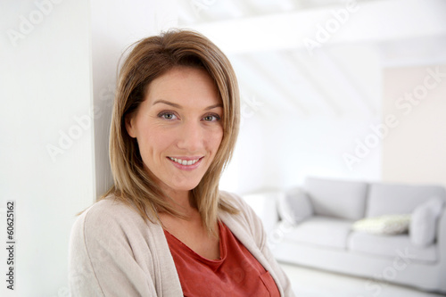 Middle-aged woman standing in modern home